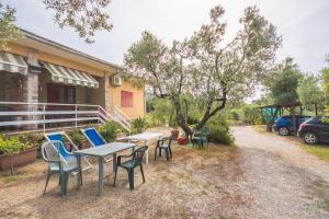 a table and chairs in front of a house at L'oleandra appartamenti in Lacona