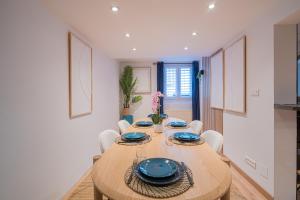 a dining room with a wooden table and chairs at SBredele - Maison de ville cosy - hypercentre in Sélestat