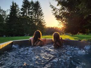 two women sitting in a jacuzzi in a tub at Resort Pasečná in Přední Výtoň