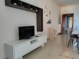 a living room with a television on a white cabinet at Levante home in Trani