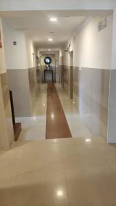 a hallway of a building with a long hallwayngth at Hotel Blu Ivy in Chennai