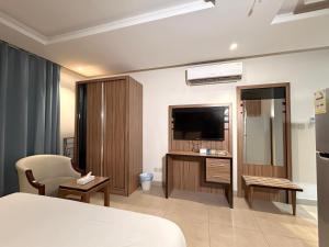 a hotel room with a bed and a television at بيت لمار 3 للشقق المخدومه in Riyadh