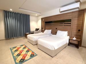 a hotel room with two beds and a window at بيت لمار 3 للشقق المخدومه in Riyadh