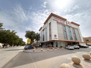 a building on a street with cars parked in a parking lot at بيت لمار 3 للشقق المخدومه in Riyadh