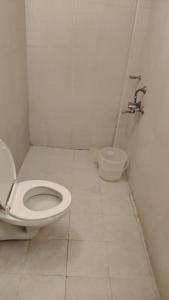 a white bathroom with a toilet and a sink at Hotel Blu Ivy in Chennai