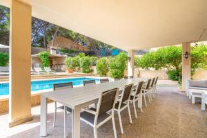 a white table and chairs in front of a swimming pool at Villa Arenas in El Arenal