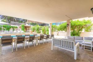 a patio with tables and chairs and a pool at Villa Arenas in El Arenal