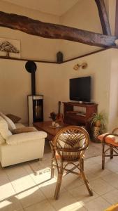 a living room with a couch and a tv at Gîte et chambres d'hôtes Aux Charlots in Lagarde-Hachan