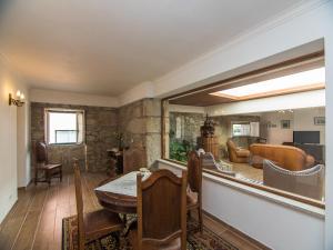 a dining room with a table and chairs and a living room at Quinta dos Avós in Viana do Castelo