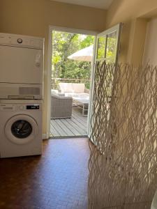 a washer and dryer in a living room with a patio at Maison Albatros in Pyla-sur-Mer