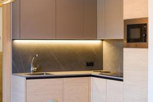 a kitchen with white cabinets and a sink at Residence Diamant in Andalo +112 photos