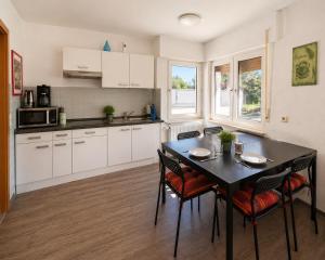 a kitchen with a table and chairs in a kitchen at Apartment Hope Inn in Groß-Zimmern
