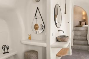 ein Badezimmer mit Waschbecken und Spiegel in der Unterkunft Aeon Suites - Adults Only by Mr and Mrs White in Pirgos