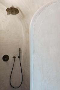 ein Badezimmer mit einer Dusche in einer weißen Wand in der Unterkunft Aeon Suites - Adults Only by Mr and Mrs White in Pirgos