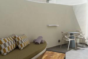 eine Couch in einem Zimmer mit Tisch und Stühlen in der Unterkunft Aeon Suites - Adults Only by Mr and Mrs White in Pirgos