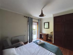 a bedroom with a bed and a chair and a window at Concha de Moledo in Moledo