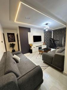a living room with a couch and a television at Skybuilt Apartment in Abuja