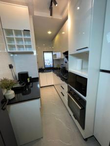 a kitchen with white cabinets and a stove top oven at Skybuilt Apartment in Abuja