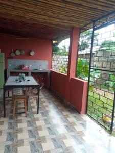 a kitchen with a table in a room with windows at Villa Marie in Nosy Be
