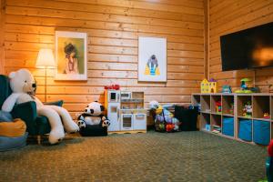 a room with stuffed animals sitting in a room with a tv at Kurpiowska Kraina in Wydmusy