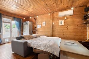 a bedroom with a bed and a wooden wall at La Cabane du Bassin in Lanton