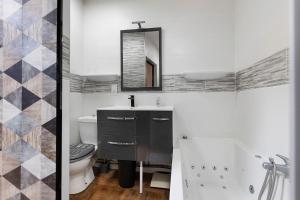 a bathroom with a sink and a toilet and a mirror at La Cabane du Bassin in Lanton +20 photos
