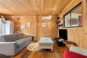 a living room with a couch and a table at La Cabane du Bassin in Lanton