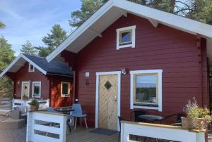 a red house with a porch and a patio at Ekenäs Camping & Gästhamn in Ekenäs