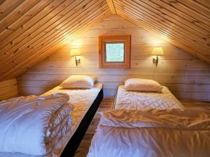 a bedroom with two beds in a log cabin at Ekenäs Camping & Gästhamn in Ekenäs +11 photos