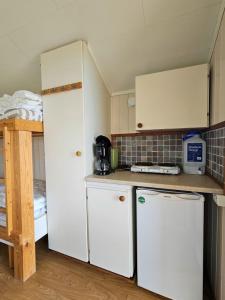 a small kitchen with white cabinets and a refrigerator at Ekenäs Camping & Gästhamn in Ekenäs