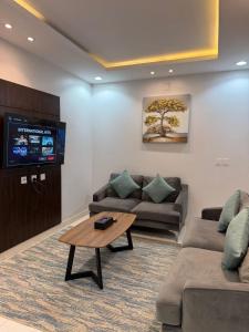 a living room with two couches and a television at Qimam Park Abha 2 in Abha