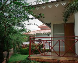 a house with a red railing on a porch at Resort Bihanga in Chālsa Mahābāri +14 photos