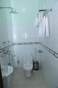 a white bathroom with a toilet and a sink at KH KH Hotel in Kasese +17 photos