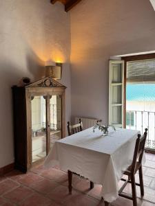 a dining room with a white table and a window at Finca Soleá in Zahara de la Sierra