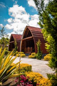 a large barn with a red roof in a garden at Noah Hotel Silangit in Siborongborong