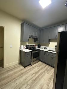 an empty kitchen with gray cabinets and wooden floors at Central LA Shared Living #2 in Los Angeles