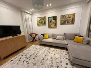 a living room with a couch and a flat screen tv at Mikpritja Korçë in Korçë