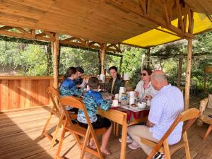 a group of people sitting at a table in a pavilion at Aika Sunrise - Your Home in the Hills in Iringa