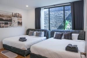 two beds in a room with a large window at Live With Passion Pool Villa in Pak Chong +237 photos