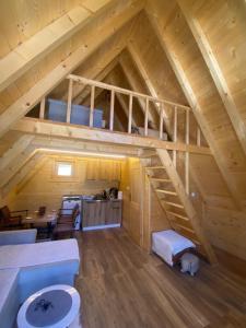an attic room with a staircase in a cabin at Guest House Višnja in Žabljak