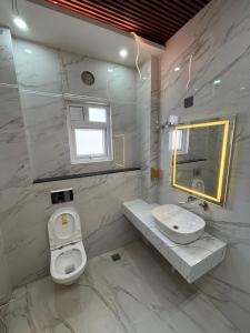 a bathroom with a sink and a toilet and a mirror at Hotel Picnic Garden in Patna