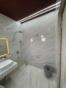 a white bathroom with a sink and a mirror at Hotel Picnic Garden in Patna