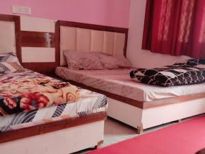 two beds sitting next to each other in a bedroom at Royal Orbit By StayApart in Sonprayag
