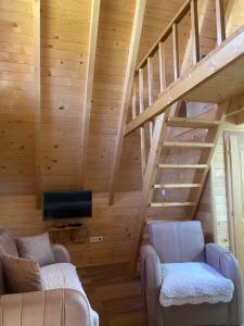 a living room with two couches and a staircase at Guest House Višnja in Žabljak