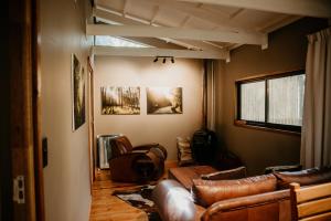 a living room with leather couches and a table at The Cabins Hogsback in Hogsback