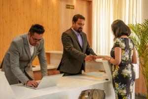 a group of three people standing around a table with a laptop at Aureva Kamla Heritage in Jaipur