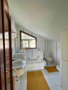 a bathroom with a tub and a sink and a toilet at The Eira - Spacious duplex with lush garden in Nigrán +31 photos