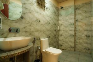 a bathroom with a sink and a toilet and a shower at Aureva Kamla Heritage in Jaipur