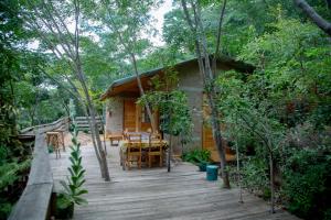 a wooden porch of a cabin in the woods at Aika Sunrise - Your Home in the Hills in Iringa
