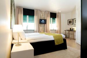 a bedroom with a bed with a lamp and a window at Hotell Tinget in Sala